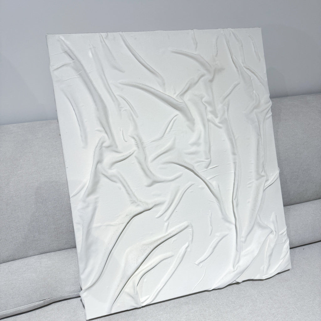 White textured pillow on a gray sofa against a gray wall