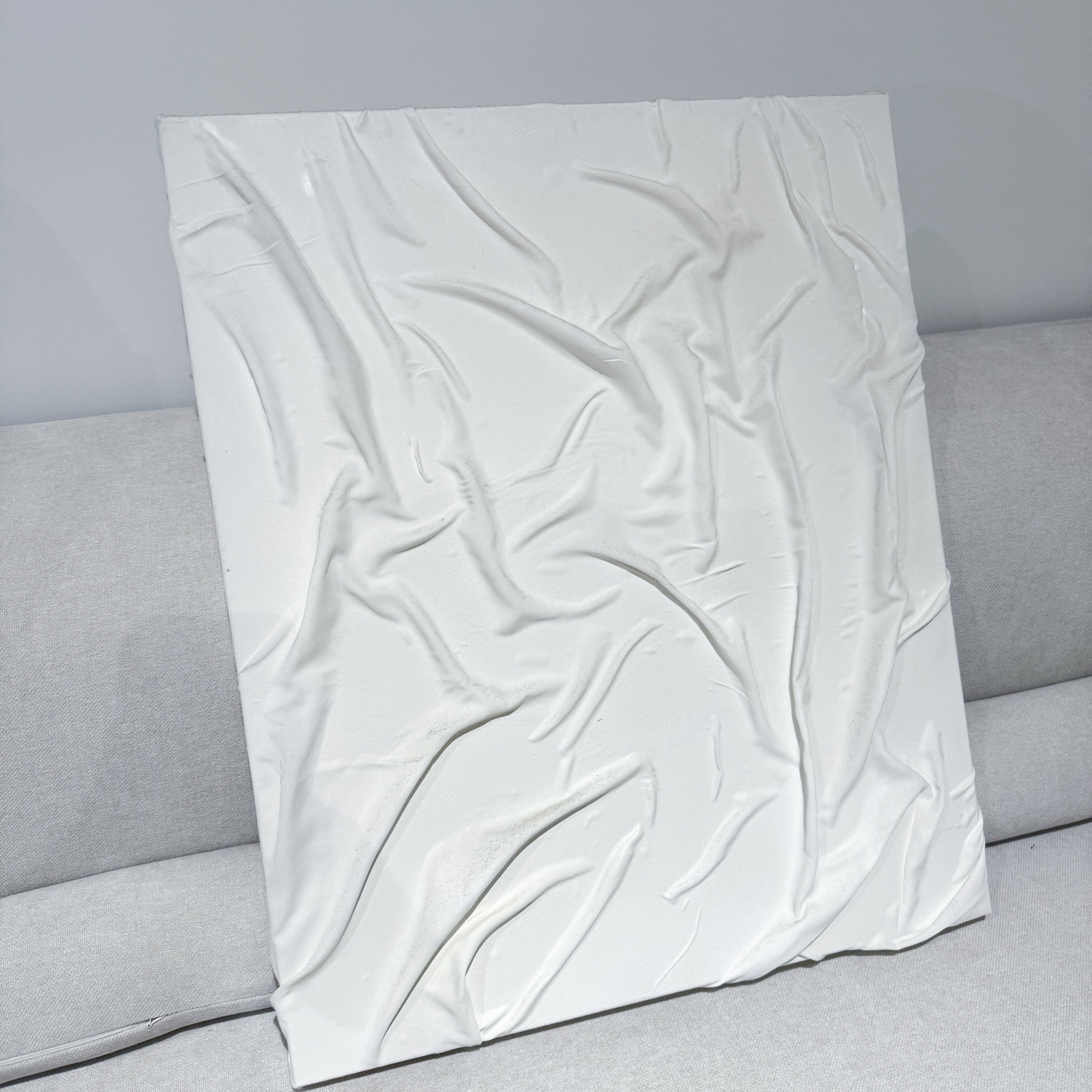 White textured pillow on a gray sofa against a gray wall